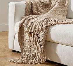 Soft knit throw blanket adding warmth and texture to a staged living room.