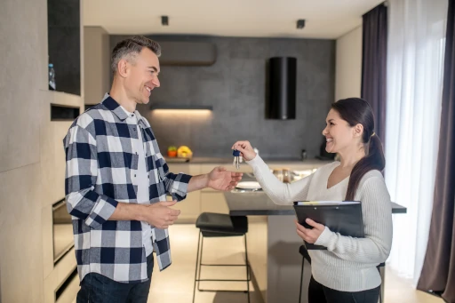 new-homeowner-checklist-closing-day New homeowner receiving house keys after closing on a home purchase.
